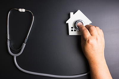 House model with stethoscope isolated on black background.Indica